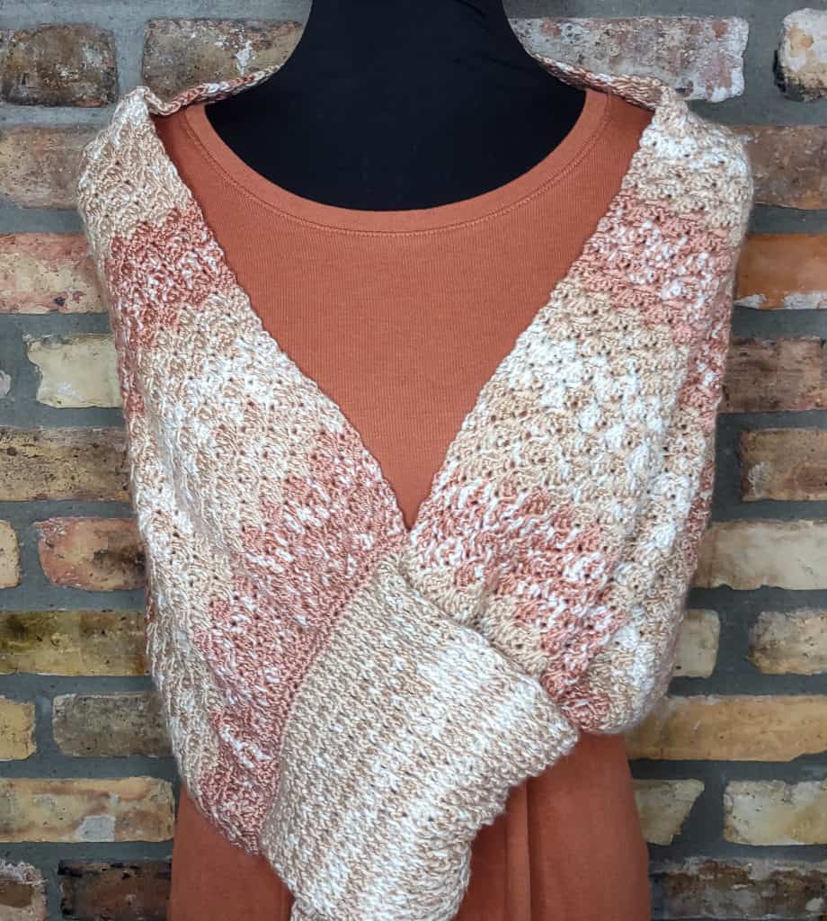 tan, white, terracotta crochet wrap on dress form with burnt orange long sleeve t shirt. 